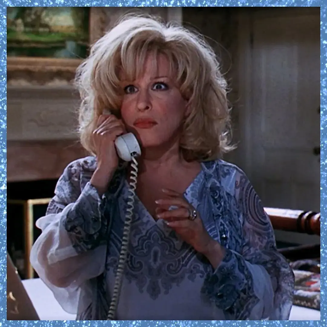 Bette Midler as Lilly Leonard looks wide-eyed while holding a white corded telephone in a scene from the 1997 film That Old Feeling.